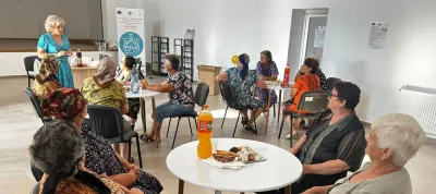 A group of women listening to a talk by a female speaker in the project building